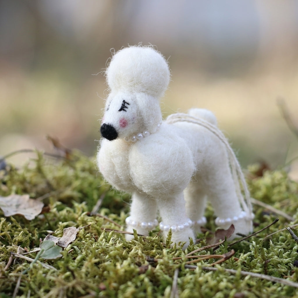 Handmade wool felt poodle dog ornament on a grassy background