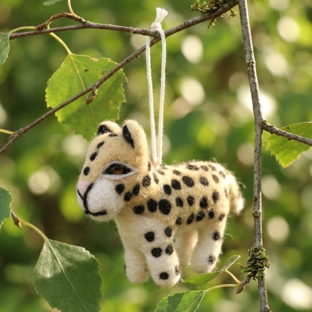 Wool felt leopard hanging decoration
hanging from a tree branch with a natural green background
