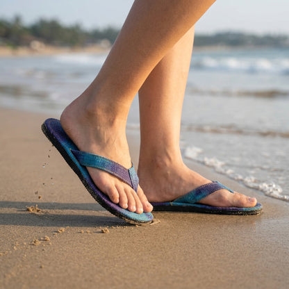 Person wearingBlue Dye Hemp Flip Flops – Plastic-Free Vegan Summer Sandals  Handmade Organic Hemp Slippers on a sandy beach with ocean in the background