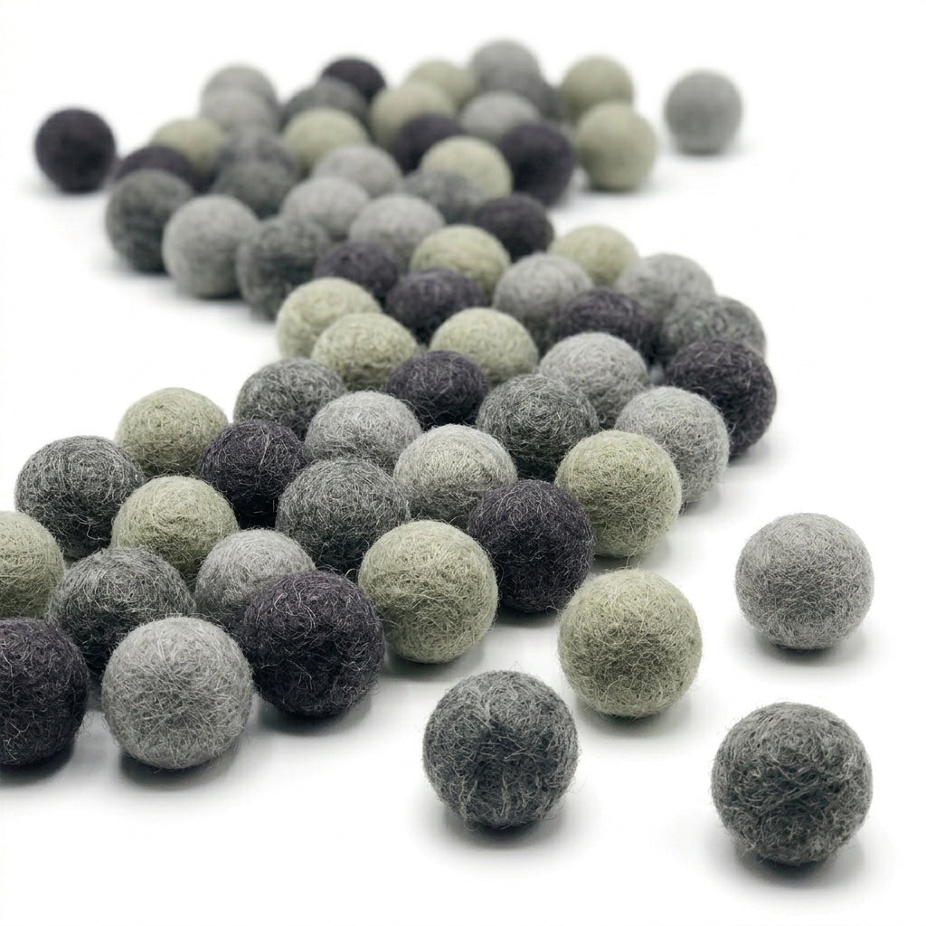 Collection of gray  felt balls for crafts and kids diy projects on a white background