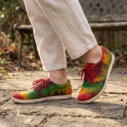 Colorful tie-dye shoes worn outdoors on a stone path.