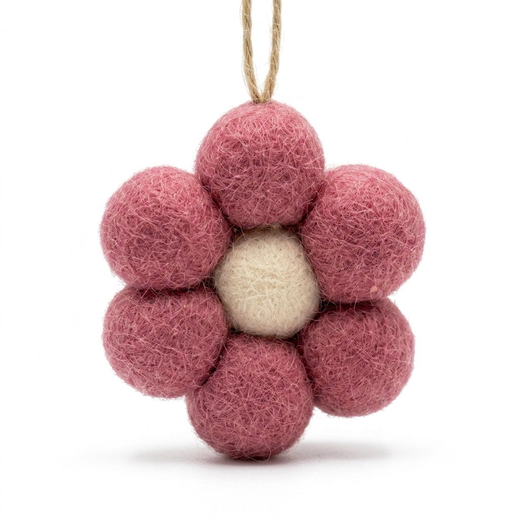 Pink felt flower ornament with a white center on a white background