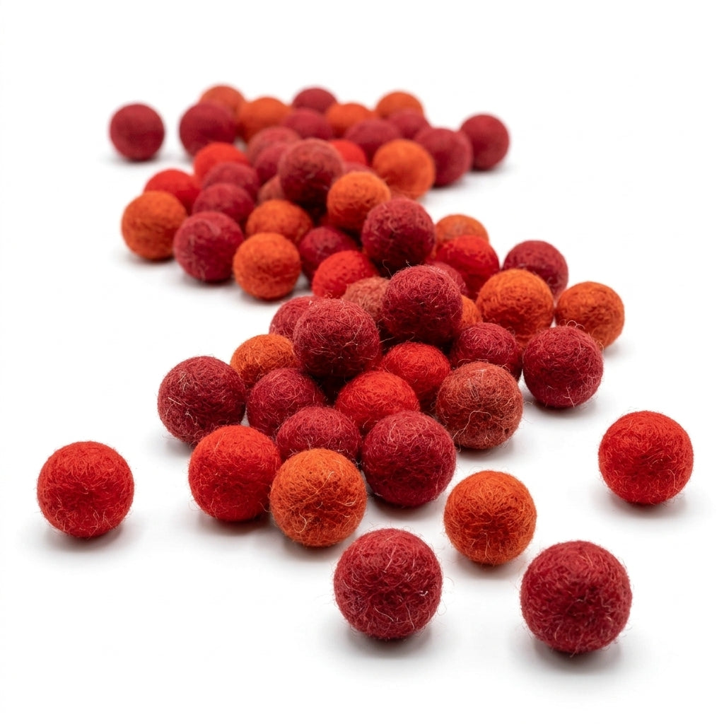 Red and orange felt balls on a white background