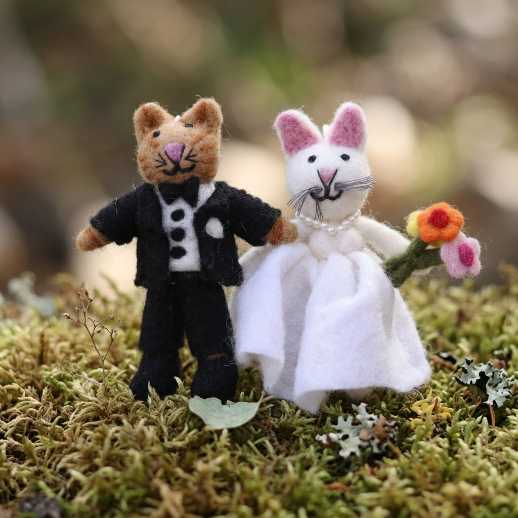 Cat couple wool felt ornament for Christmas tree decor, standing on a mossy surface.