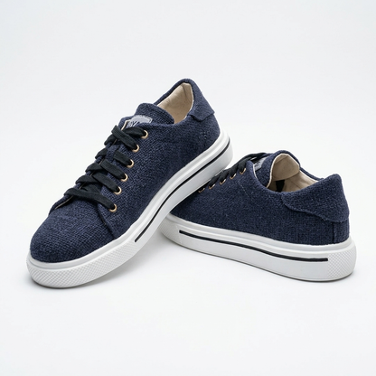 A pair of dark navy organic hemp canvas lace-up shoes with black laces, gold eyelets and white natural rubber soles on a clean white background.

