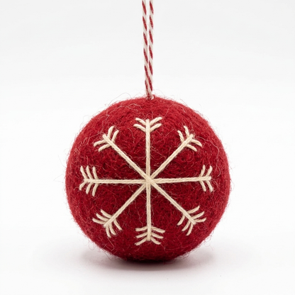 A handmade red wool felt Christmas bauble ornament with a cream embroidered snowflake, hanging from a red-and-white cotton loop against a plain white background.

