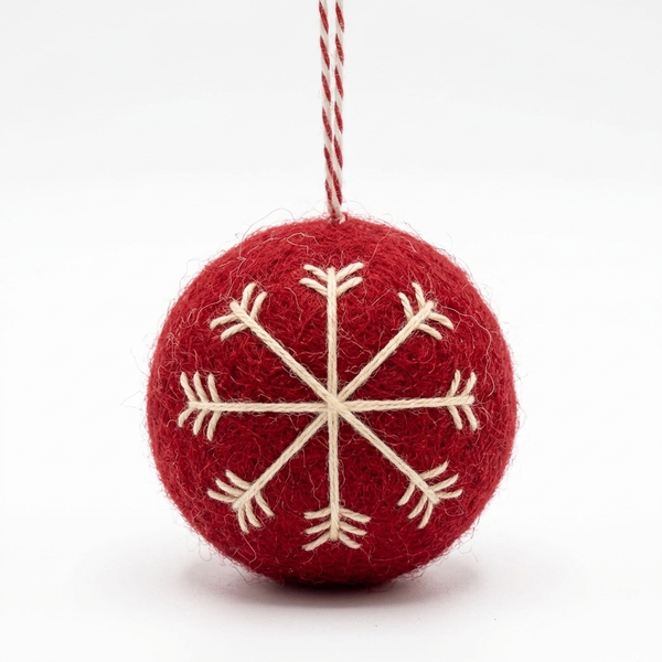 A handmade red wool felt Christmas bauble ornament with a cream embroidered snowflake, hanging from a red-and-white cotton loop against a plain white background.

