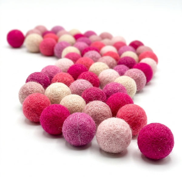 pink felt balls for crafts and diy projects on a white background