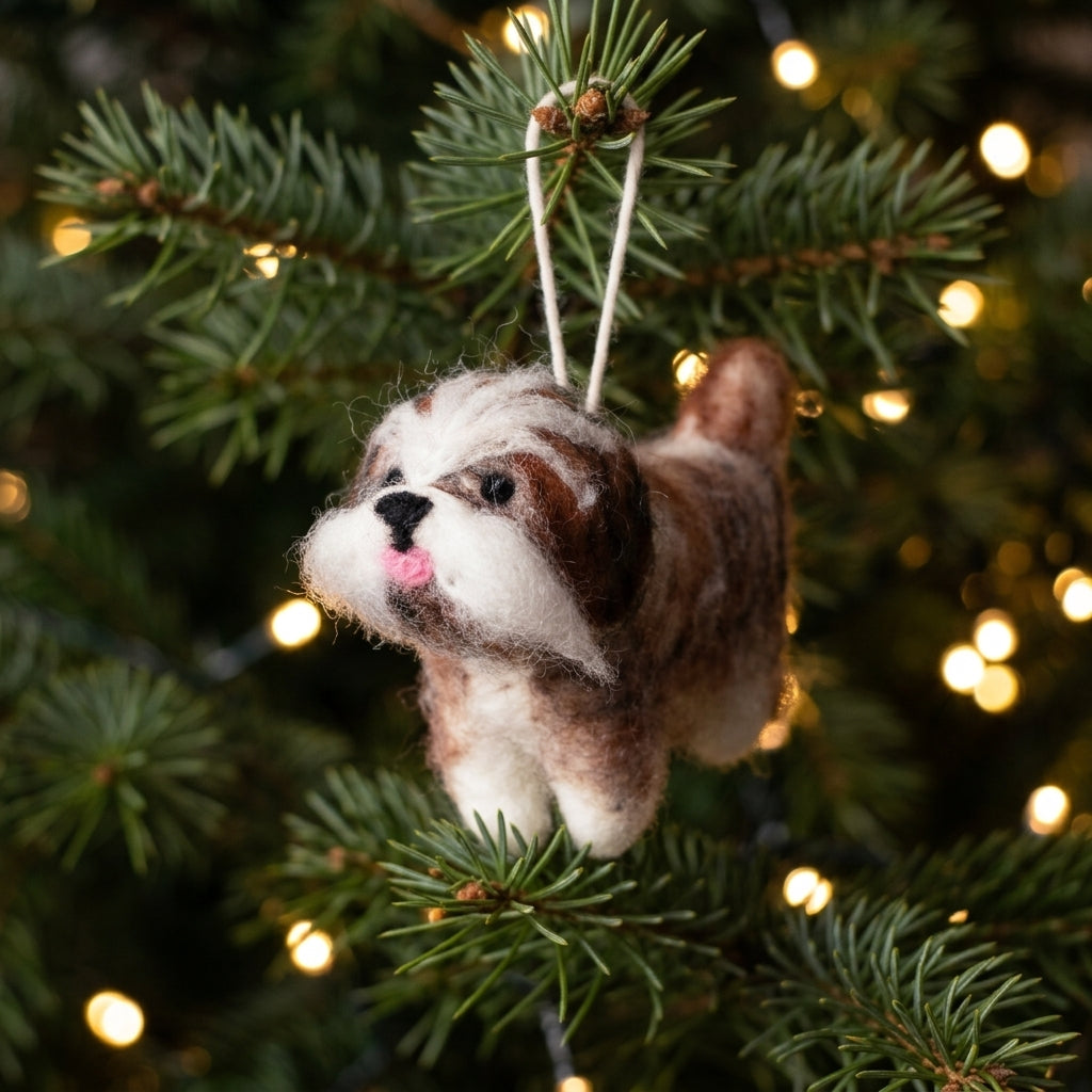 Handmade wool felt Shih Tzu dog ornament with hanging thread Christmas ornament on a decorated tree with lights.